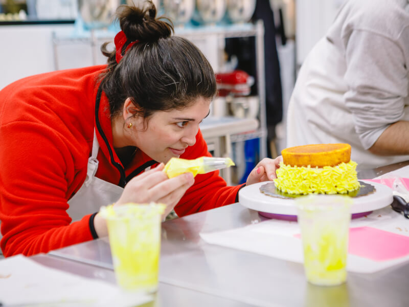 Person concentrating while working at a cake decorating class